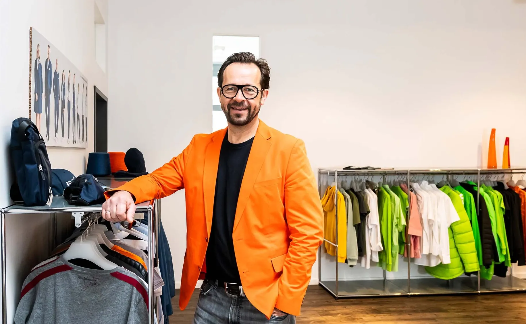 Michael Jefferys im Showroom zwischen Kleiderstangen mit Corporate Fashion